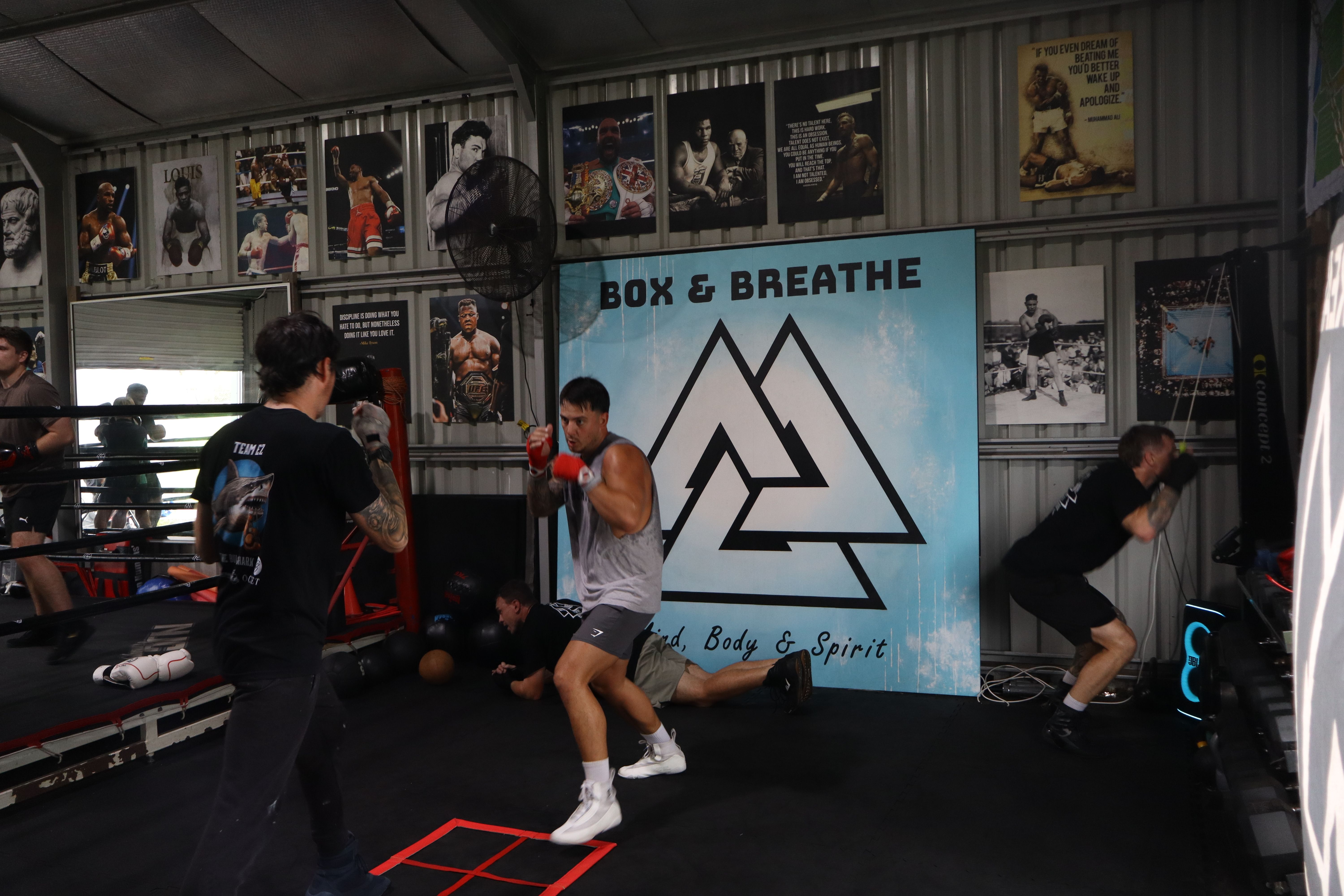 A boxer training in front of the Box & Breathe banner