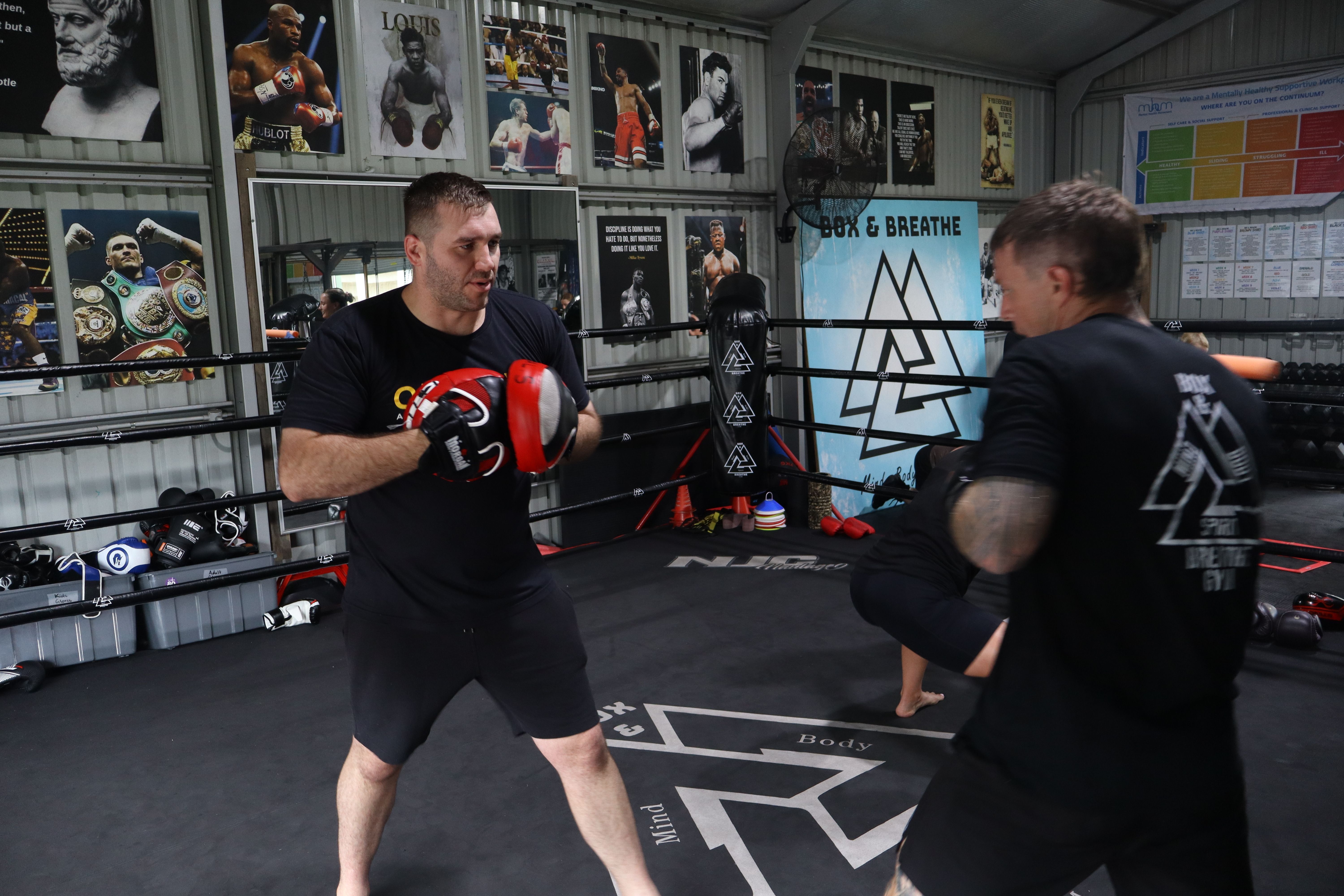 Coach guiding a beginner through pad work