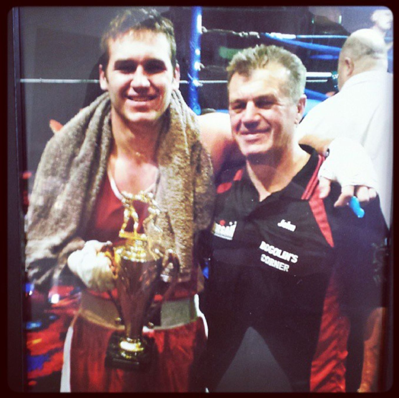 A young Dan Bogolin holding a trophy beside his father John in his Bogolin's Corner gear