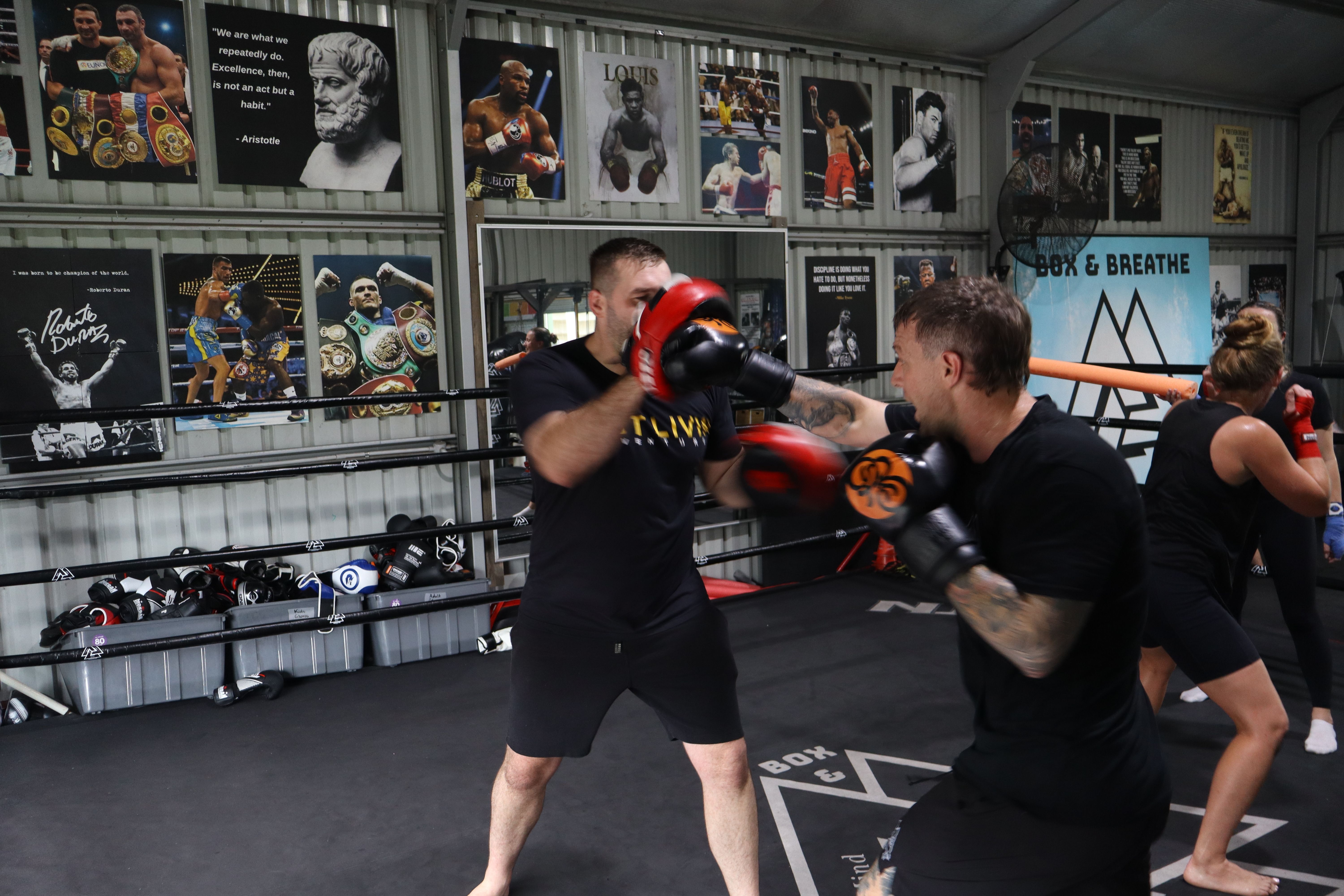 Coach holding pads for a boxer at Box & Breathe